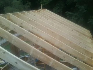 New roof rafters set over an addition before sheathing in Melvin