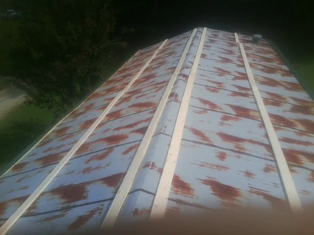 Rusted metal roof panels with new wood purlins before replacement — Storm Damage Roof Repair in Melvin by Roofing Brothers