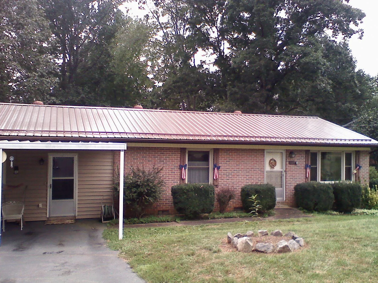 Bronze metal roof and carport on a brick ranch home — Roof Repair work by our crew in Melvin