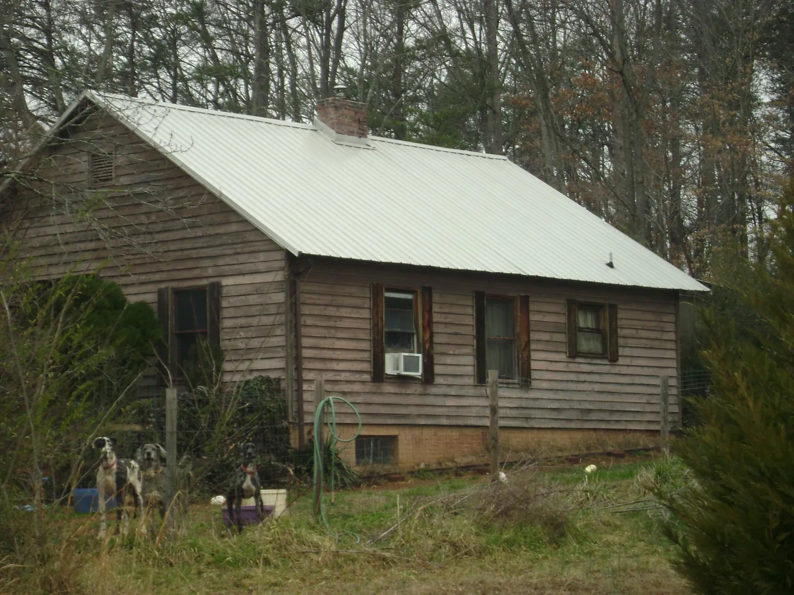 White metal roof on an old wood sided farmhouse, from a Metal Roof Installation job in Melvin